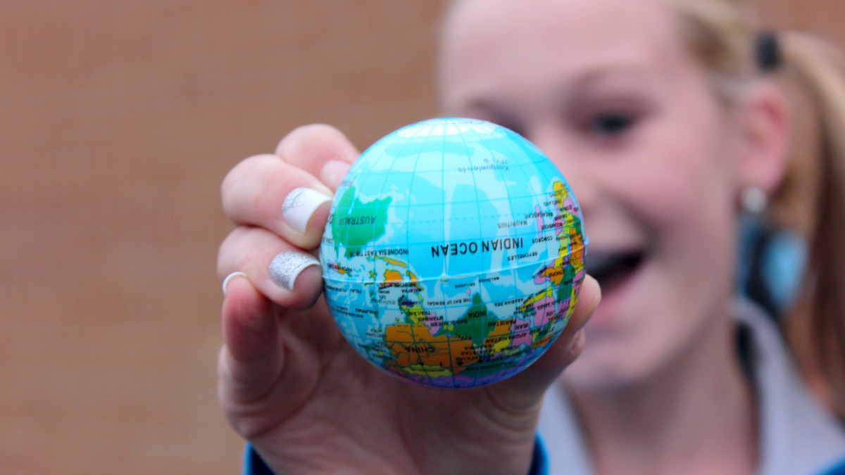 A small globe held by a girl upside down with Indian Ocean facing camera