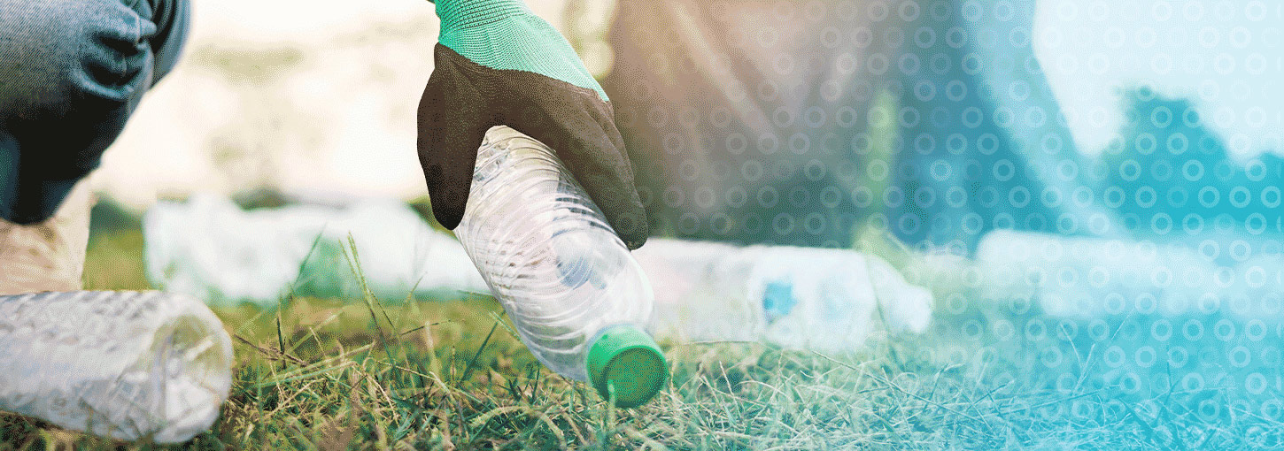 Someone picks up empty water bottles on the ground.